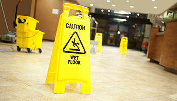 a hallway with wet floor signs, representing premises liability
